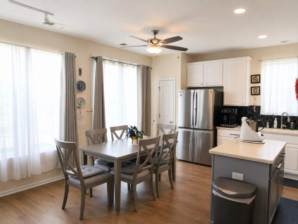 Eat-in kitchen area with bay windows and stainless refrigerator